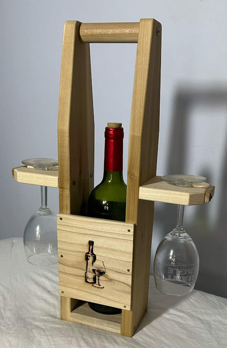 A light reclaimed-pine caddy holding an upright wine bottle with two glasses hung beneath.
